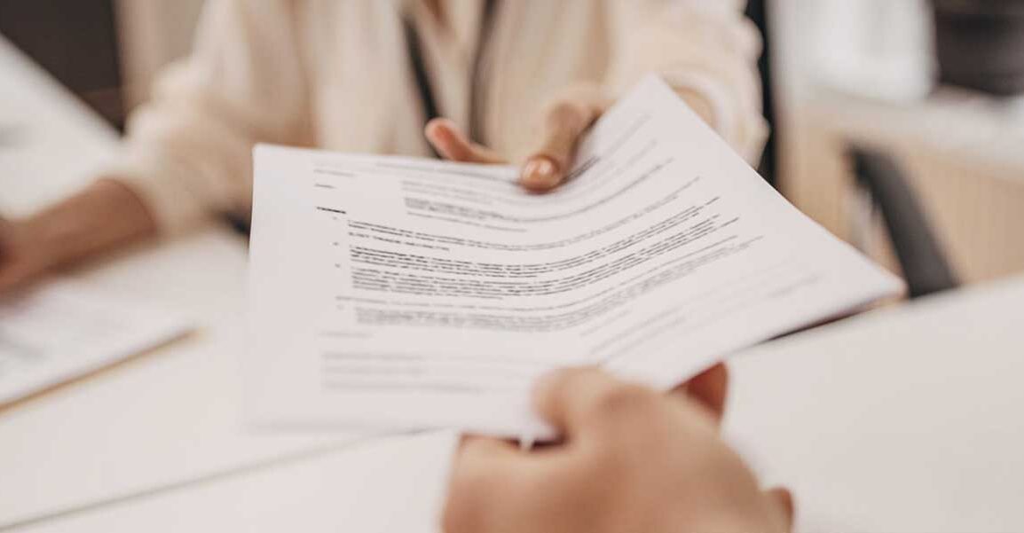 Nutricionista entregando documento impresso ao paciente durante atendimento.