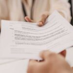 Nutricionista entregando documento impresso ao paciente durante atendimento.